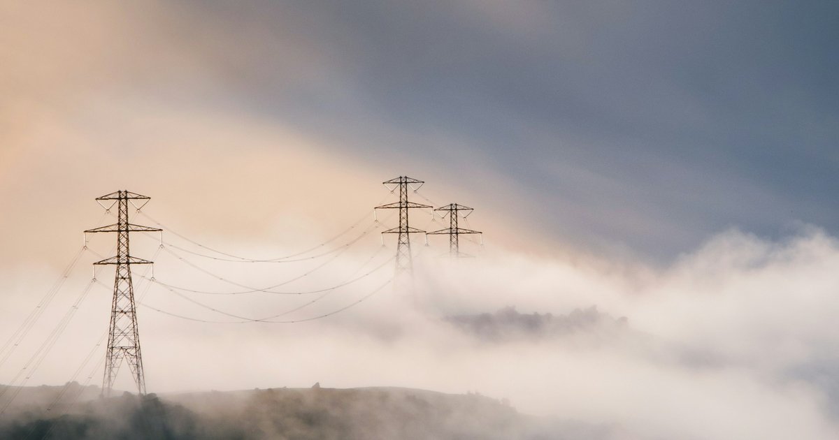 霧の中に立つ送電線の鉄塔