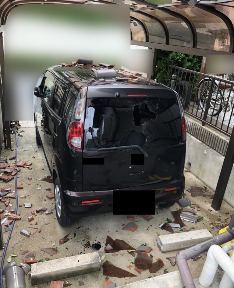 瓦がカーポートの屋根を突き抜けて落ち、後ろのガラスが割れた車